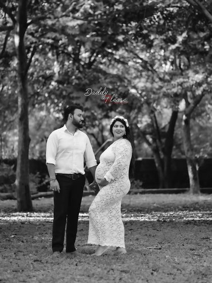A classic black and white composition of an expecting couple in a park. The focus is entirely on their interaction and the anticipation of their new arrival.