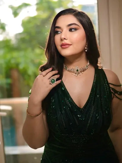 A beautiful candid shot of the bride by the window. The natural light catches the subtle shimmer on her eyes and the healthy glow on her skin, showcasing the dimension of the makeup.