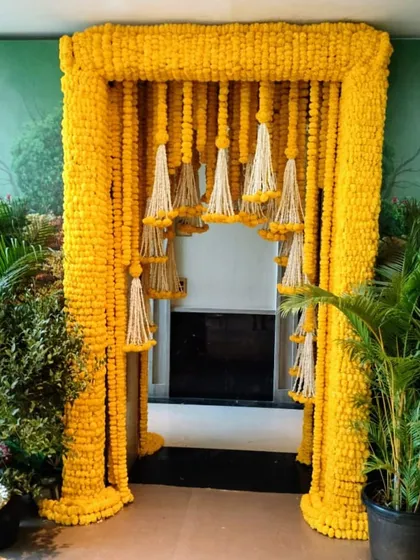 This magnificent entrance arch is made entirely of yellow marigolds, with hanging tassels of white tuberoses (rajnigandha) creating a dramatic and traditional welcome for a wedding event.