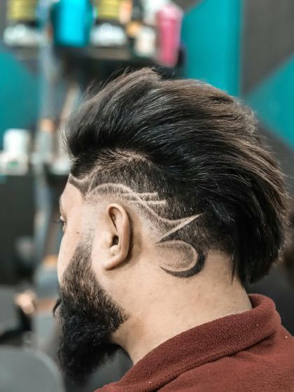 On the way to a great look. This image captures the process of creating a detailed razor design on the side of a fade.
