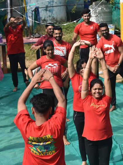 A joyful moment during a group retreat, with participants smiling as they stretch. Wellness should feel good.