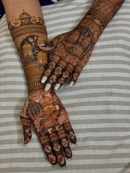Another beautiful bridal design with a mix of traditional motifs, including palaces, peacocks, and personalized initials on the fingers.