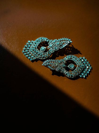 A close-up, artistic shot of a pair of diamond earrings, with dramatic lighting highlighting their sparkle and intricate design.