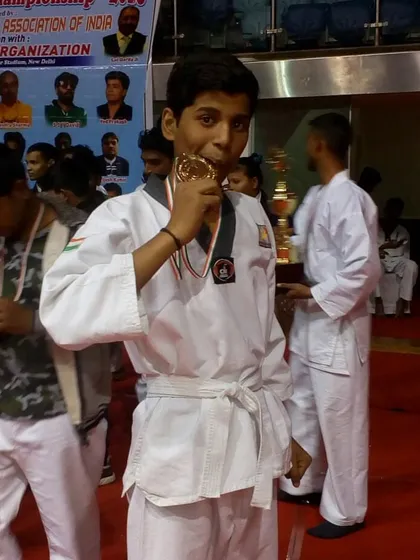 A champion bites his gold medal, a classic pose celebrating a hard-fought victory.