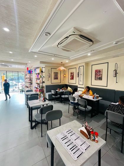 Our comfortable cafe seating area, with modern decor and soft lighting. It's the perfect spot to relax and enjoy a meal with friends or family.