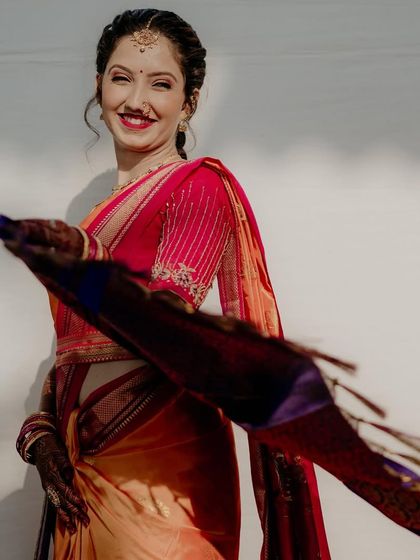 A dynamic and joyful shot of the bride twirling, her saree's pallu caught in motion. Her bright smile captures the happiness of the moment.