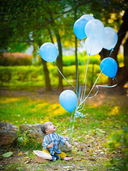 Looking up at the balloons with wonder. This is a classic and beautiful shot for any outdoor birthday celebration.