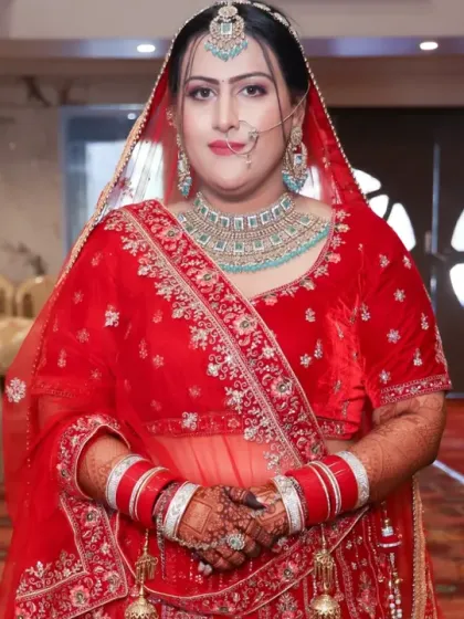 A full-length shot of the bride in her gorgeous red lehenga, with her mehandi-adorned hands completing the look.