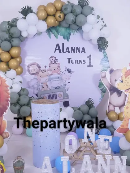A sweet jungle theme for a first birthday, with cute, cartoonish animal cutouts. The green and gold balloon arch is accented with white balloons for a softer look.