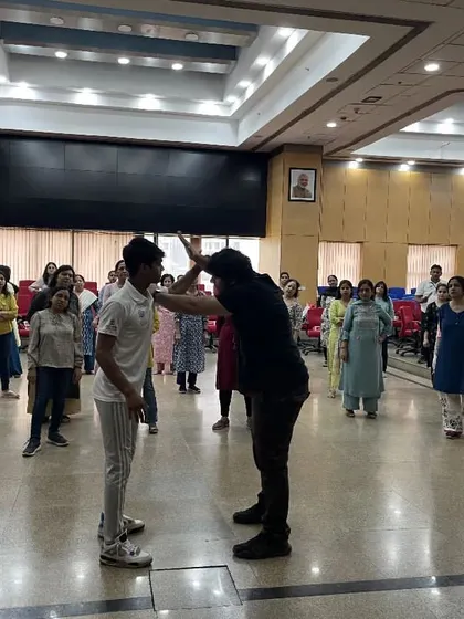 During a corporate workshop, I demonstrate a defense against a two-handed push or grab. This technique redirects the opponent's force and puts you in a dominant position.
