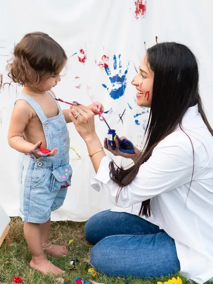 A mother and child painting together outdoors is a beautiful, interactive theme for a photoshoot. It allows for genuine connection and playful moments.