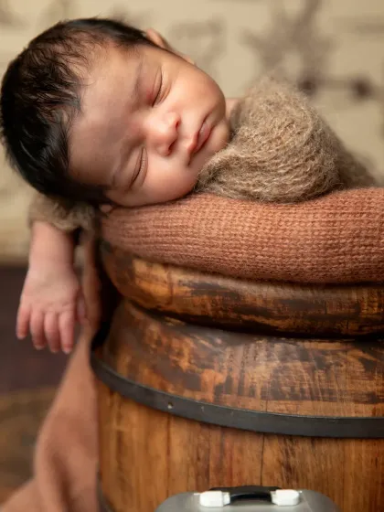 A different take on the traveler theme, with the baby sleeping peacefully in a rustic wooden barrel, ready for a grand voyage.