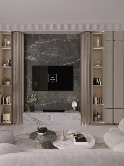 We designed this living room as a calm retreat, using soft, rounded furniture and a neutral color palette. A dark marble accent wall behind the TV provides a grounding contrast to the light-filled space.