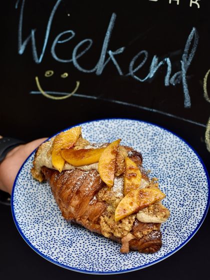 The Peach & Almond Twice-Baked Croissant is a celebration of seasonal fruit. We fill it with almond frangipane and top it with fresh, juicy peaches before baking it a second time until golden.