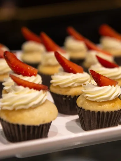Vanilla cupcakes topped with cream cheese frosting and a fresh strawberry slice. These bite-sized treats are perfect for high-tea events or as part of a larger dessert buffet.
