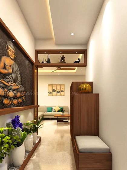 A serene foyer design leading into the living area. This space features a large Buddha wall art piece and a built-in seating nook, creating a tranquil and welcoming entrance.