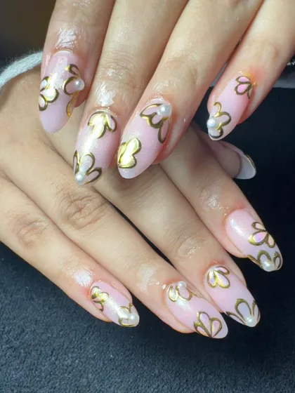 An example of elegant hand-painted work. This set features a soft pink gel base with intricate gold floral outlines and tiny pearl accents, perfect for a sophisticated and timeless style.