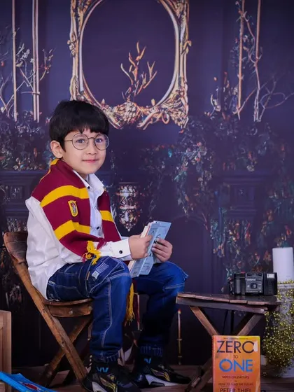 A thoughtful young wizard in our Harry Potter themed set. The rich, dark background and vintage props create a wonderfully atmospheric portrait for any fan of the series.