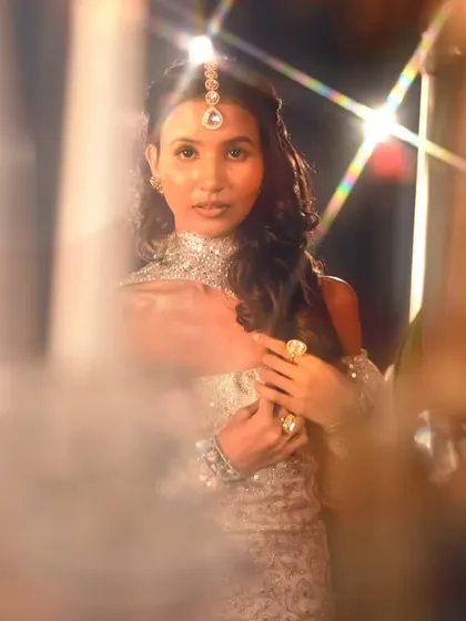 A creative shot using lens flare to create a magical, dreamlike effect. The makeup and hair hold up beautifully under professional lighting.