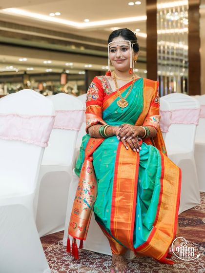 A serene portrait of the bride, seated and waiting for the ceremony to begin, looking absolutely radiant in her traditional attire.
