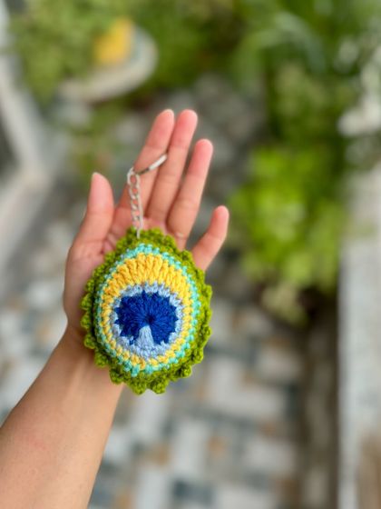 A close-up of our MorPankh keychain, showing the beautiful details of the peacock feather.