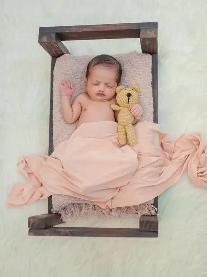 A classic newborn portrait using a miniature bed prop and a soft teddy bear. I have a wide selection of props and textures at my studio to customize your baby's first photoshoot.