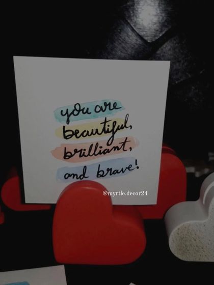 A close-up of our hand-painted Polaroid card, held in our red heart photo holder. A perfect little reminder for your desk or bedside table.