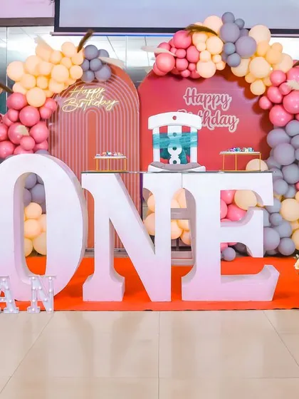 A modern and stylish first birthday decor setup with a teddy bear theme and a warm color palette.