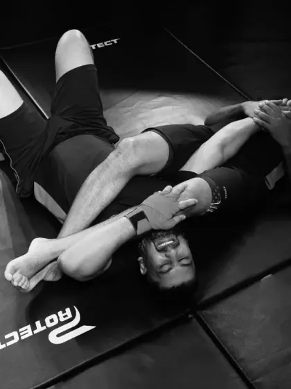 The ground is our ocean. This black and white shot captures the intensity of our grappling training, where students learn essential BJJ submission techniques like the armbar, focusing on leverage and control.
