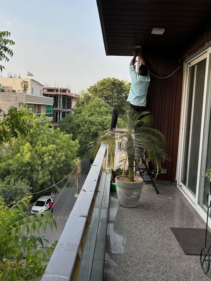 Installing an outdoor camera on a balcony to monitor the street below. This type of camera is essential for perimeter security in residential areas.