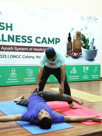 Guiding a participant through a gentle spinal twist during a yoga therapy session at ONGC. Twists are essential for releasing tension in the spine and improving digestive health.