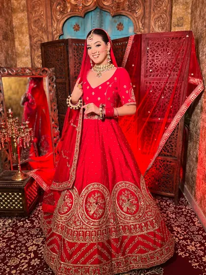 Nothing beats the timeless elegance of a classic red bridal lehenga. This piece features rich embroidery and a traditional silhouette, perfect for the bride who wants that iconic maharani look for her wedding ceremony.