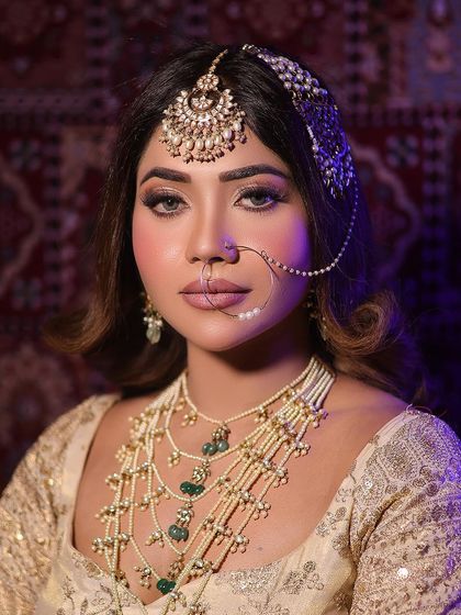 A direct, confident look from the model, showcasing the full beauty of the layered necklace and head jewellery.