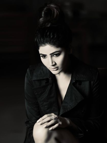 A pensive, low-key portrait in black and white. The soft, directional lighting sculpts the face and creates a quiet, cinematic mood.