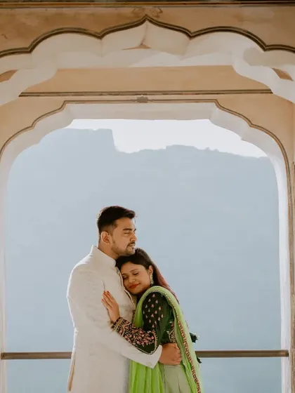 A tender embrace framed by a palace archway, with the mountains in the distance. This silhouette-style shot is perfect for capturing a quiet, romantic mood during a pre-wedding shoot.