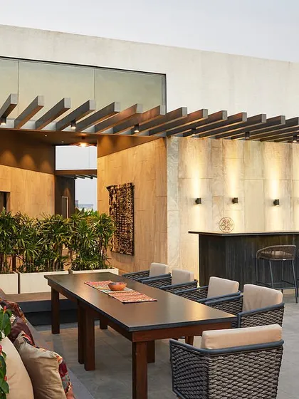 This rooftop terrace for The Bandra Project was designed as a spectacular retreat at dusk, complete with a bar, dining area, and strategic landscaping to offer stunning city views.