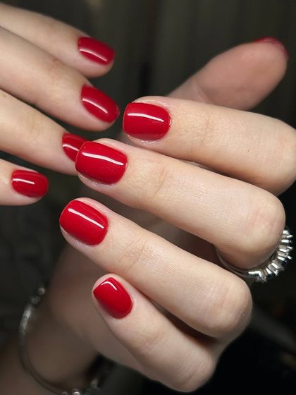 A classic, bright red manicure on short, natural nails. The impeccable application and high-gloss finish make this a standout look.