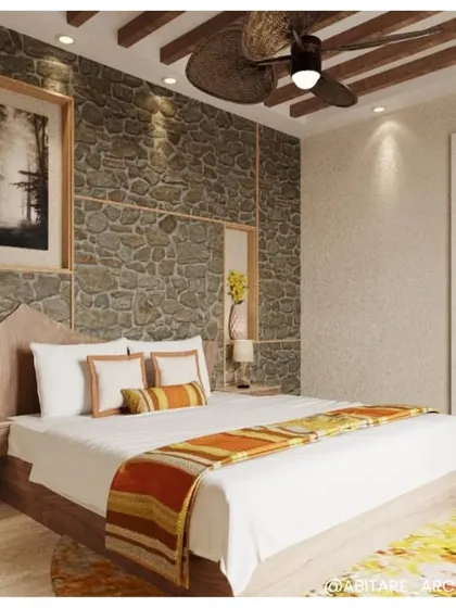 A well-lit view of the bedroom at Dev Villas. The combination of the stone wall, wooden bed frame, and warm accent colors on the runner creates a cozy and inviting atmosphere.