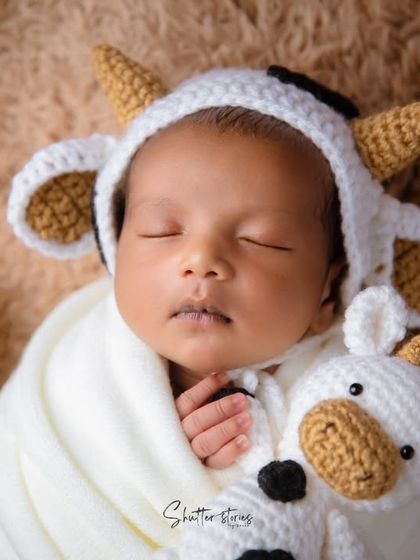 A close-up of our little cow, sleeping soundly with his matching cow plushie.