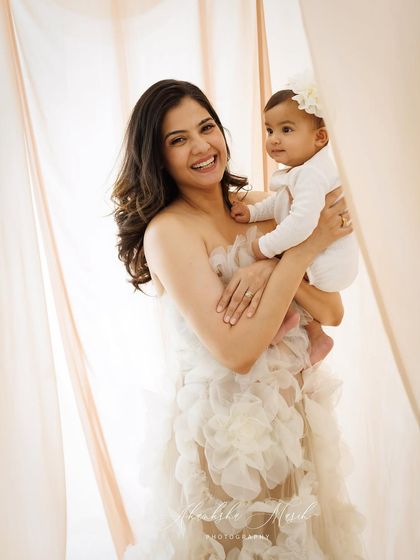 The joy on this mother's face says it all. Holding her baby close, this portrait captures a moment of pure happiness and the beautiful bond they share.