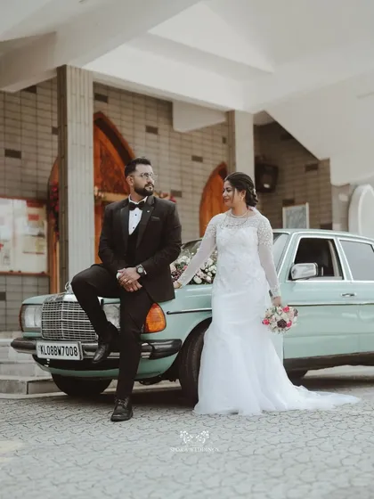 The bride and groom posing with a vintage mint-green car, a perfect example of the unique luxury transport I can arrange for your day.