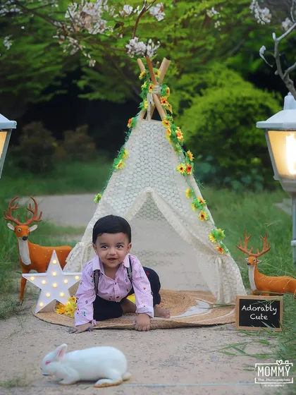 An adorable outdoor adventure! This boho-chic sitter session features a lace teepee, woodland friends, and glowing lanterns, creating a whimsical setting for this little explorer. Outdoor baby portraits have such a beautiful, natural feel.