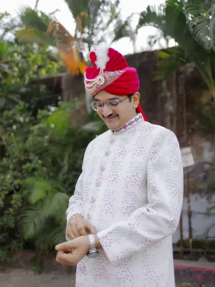 A candid shot of the groom adjusting his watch, a classic pose that adds a touch of style and anticipation.