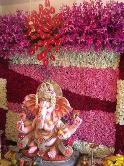 A multi-colored floral wall featuring stripes of red, pink, and white flowers, topped with exotic purple orchids. This design is for those who love a rich and varied color palette for their festivities.