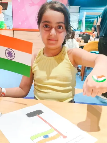 A girl proudly holds an Indian flag and shows her flag tattoo during our Independence Day event.