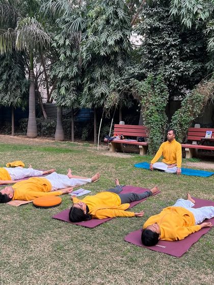 Fledgling teachers practicing Savasana (Corpse Pose) in the park. Even relaxation is a skill that we learn to teach effectively.