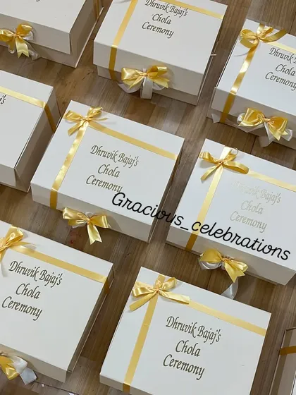 We personalize every detail, right down to the gift box. These elegant white boxes for a Chola ceremony feature the event details in gold foil, finished with a beautiful satin ribbon.