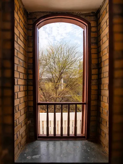 This arched window is framed by walls made of stabilized earth blocks. The soil for these blocks was excavated directly from the building's basement, a prime example of using local, low-carbon building materials.