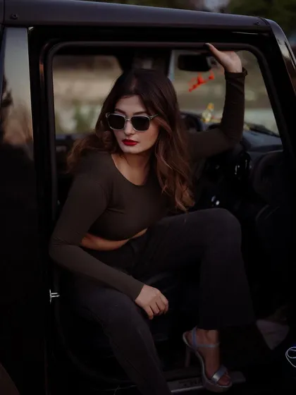 A moody portrait of a model in a car at dusk. The low light and her expression create a cinematic and intriguing image.