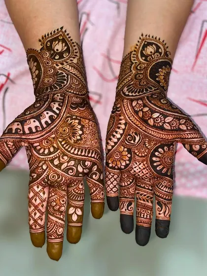 An elaborate design filled with traditional motifs, including elephants, lotuses, and intricate floral patterns, perfect for a bride or close family member.